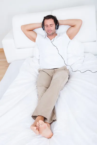 Joven escuchando música en los auriculares — Foto de Stock