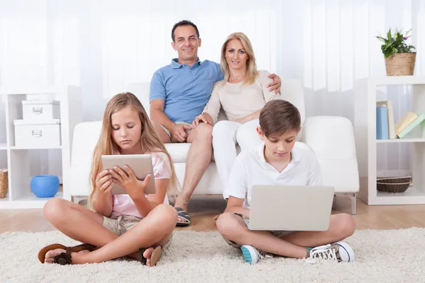 Niños en la alfombra usando tableta y computadora portátil — Foto de Stock