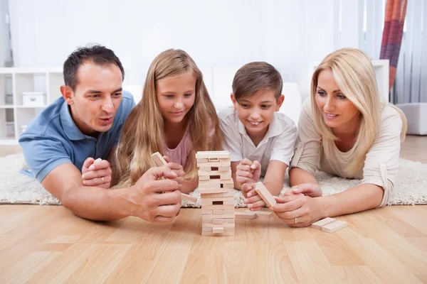Família feliz brincando com os blocos de madeira — Fotografia de Stock