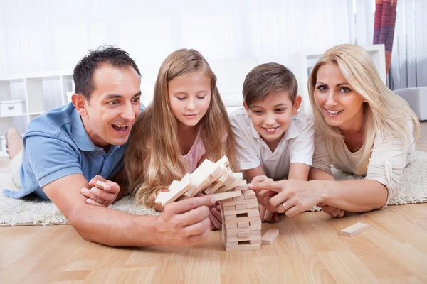 Lyckliga familjen kollapsar träklossar — Stockfoto