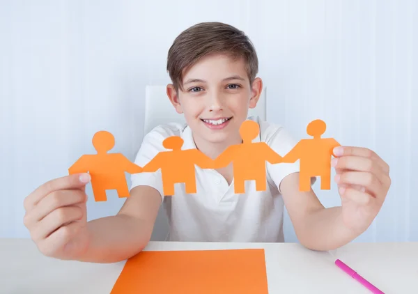 Junge hält Figuren der Papierfamilie in der Hand — Stockfoto