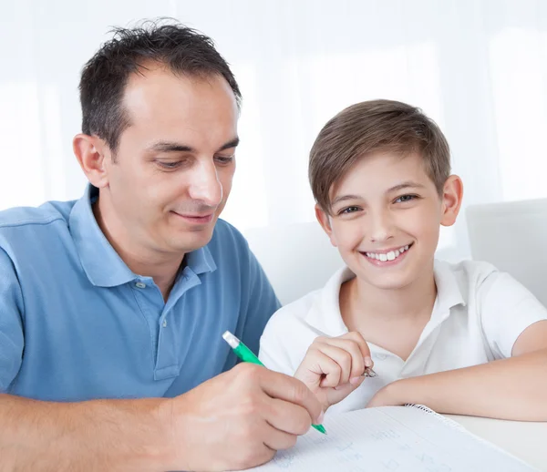 Портрет отца и сына, выполняющих домашнюю работу — стоковое фото