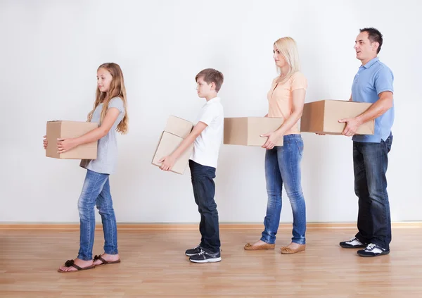 Eltern und zwei Kinder mit Kartons — Stockfoto