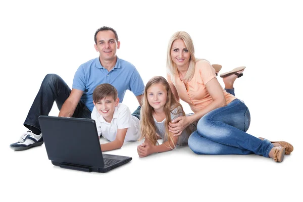 Família feliz com duas crianças usando laptop — Fotografia de Stock