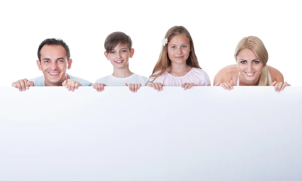 Retrato de la familia detrás del tablero en blanco — Foto de Stock