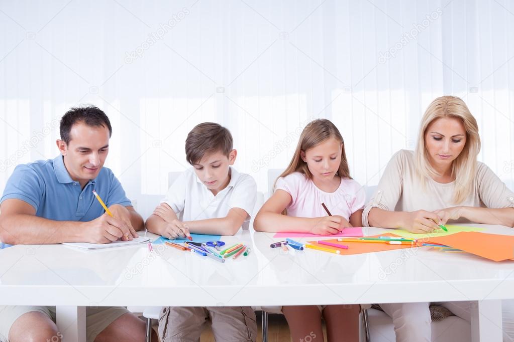 Family Drawing Together With Colorful Pencils