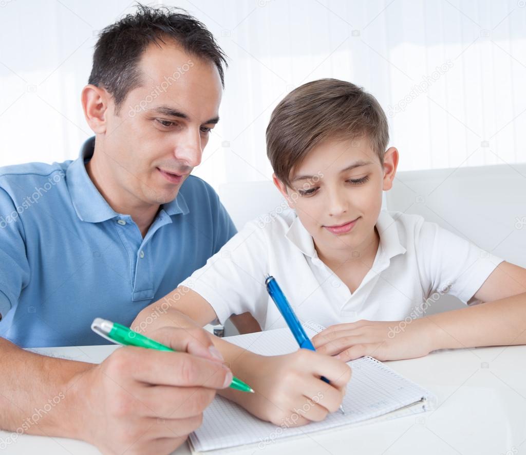 Portrait Of Father And Son Doing Homework