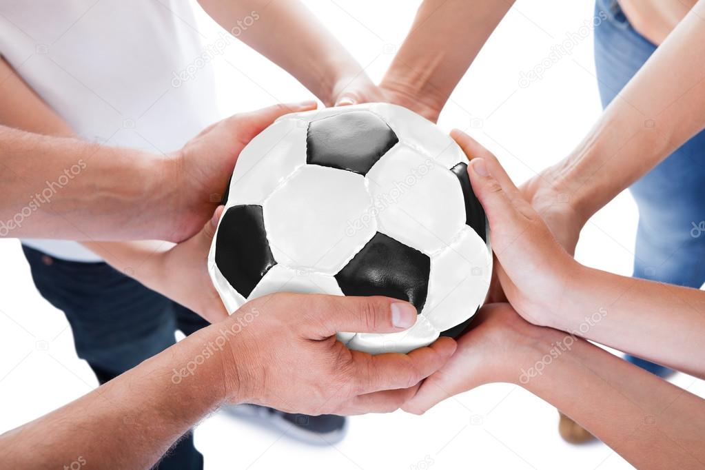 Several Hands Holding Together Soccer Ball