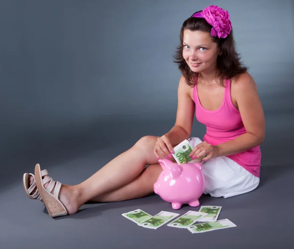 Vrouw 100 euro notities opslaan in een spaarpot — Stockfoto