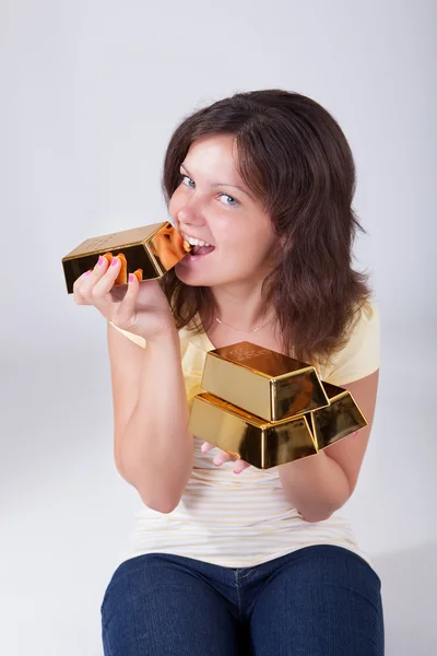 Mulher comendo barras de ouro — Fotografia de Stock