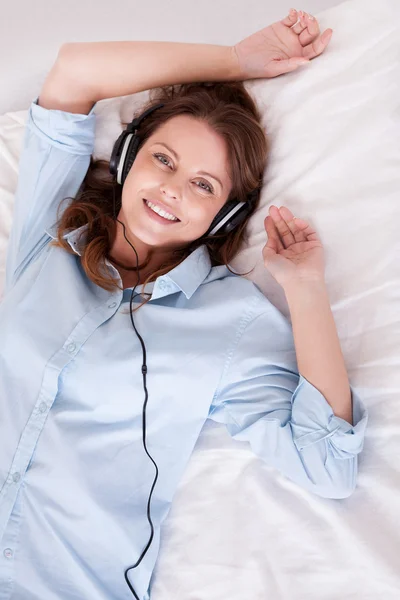 Mujer relajante escuchando música en la cama —  Fotos de Stock