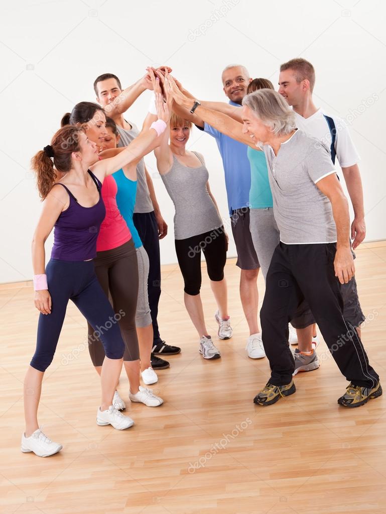 Healthy Friends High Fiving in Gym