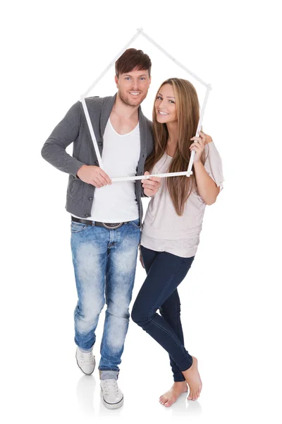 Lächelndes Paar posiert in einem Rahmen — Stockfoto