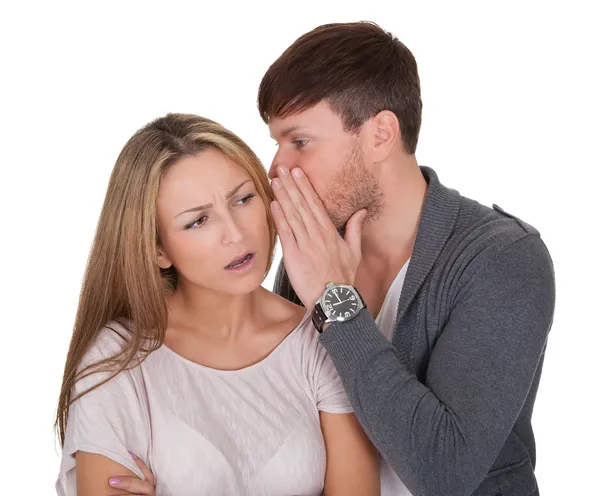 Man whispering in a woman's ear — Stock Photo, Image