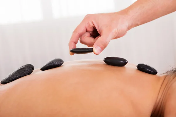 Hot stones lined on her back — Stock Photo, Image