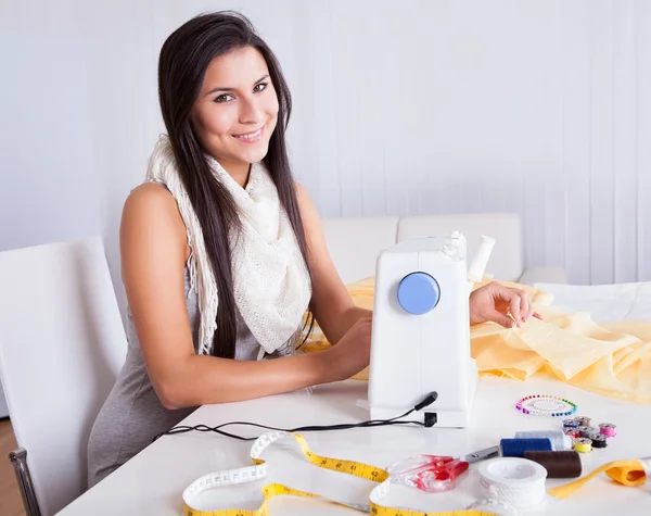 Женщина работает со своей швейной машинкой — стоковое фото