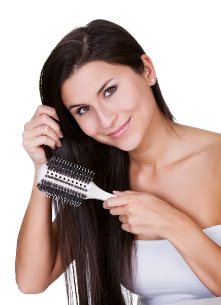 Smiling woman brushing long brunette hair — Stock Photo, Image