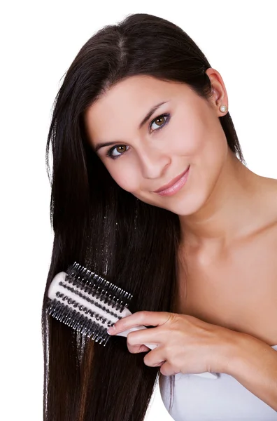 Smiling woman brushing long brunette hair — Stock Photo, Image