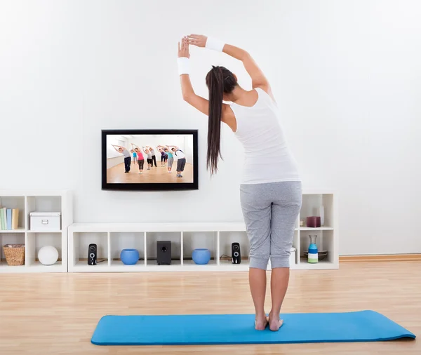 Vrouw die thuis yoga beoefent — Stockfoto