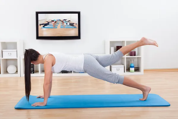 Mujer practicando yoga en casa — Foto de Stock