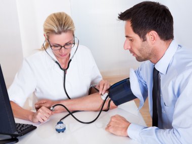 Doctor taking a patients blood pressure clipart