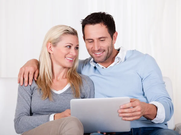 Casal olhando para um tablet juntos — Fotografia de Stock