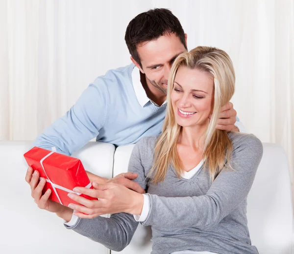 Man geeft zijn vrouw een verrassingsgeschenk — Stockfoto