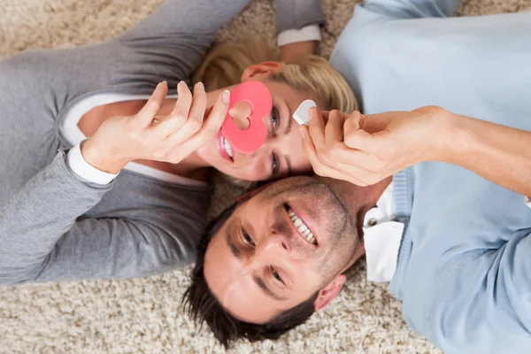 Man and woman lying head to head on the carpet — Stock Photo, Image