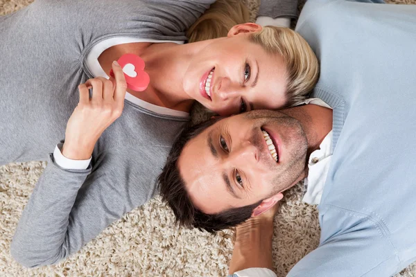 Hombre y mujer acostados cabeza a cabeza en la alfombra —  Fotos de Stock