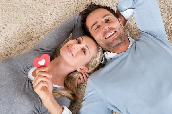 Mann und Frau liegen Kopf an Kopf auf dem Teppich — Stockfoto