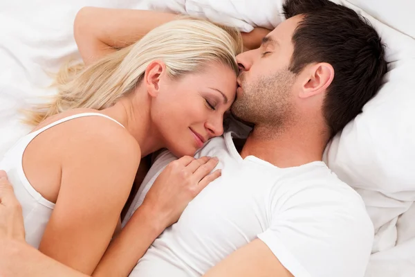 Loving couple lying in bed — Stock Photo, Image