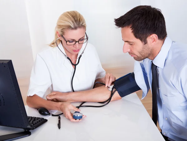 Лікар приймає кров'яний тиск пацієнтів — стокове фото
