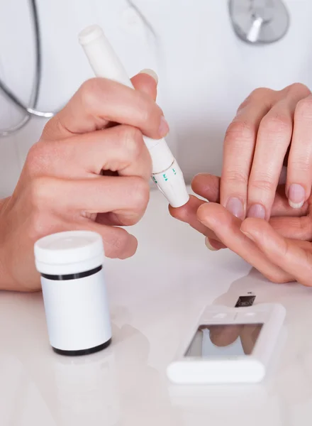 Arts een patiënten bloedglucose niveau testen — Stockfoto