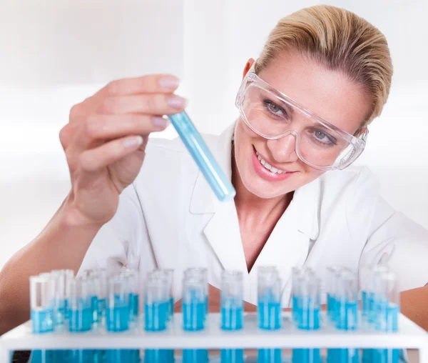 Técnica de laboratório mulher olhando para testubes — Fotografia de Stock