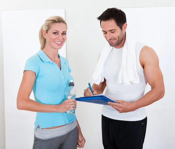 Fitness instructor taking notes after a session — Stock Photo, Image