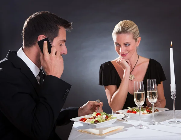 Homme prenant un appel mobile pendant le dîner — Photo