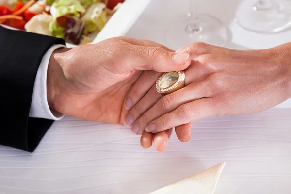 Homem e mulher de mãos dadas durante o jantar — Fotografia de Stock