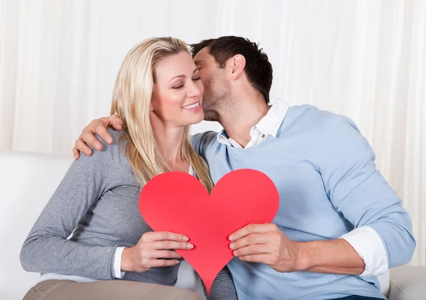 Romantic couple holding a red heart Stock Picture