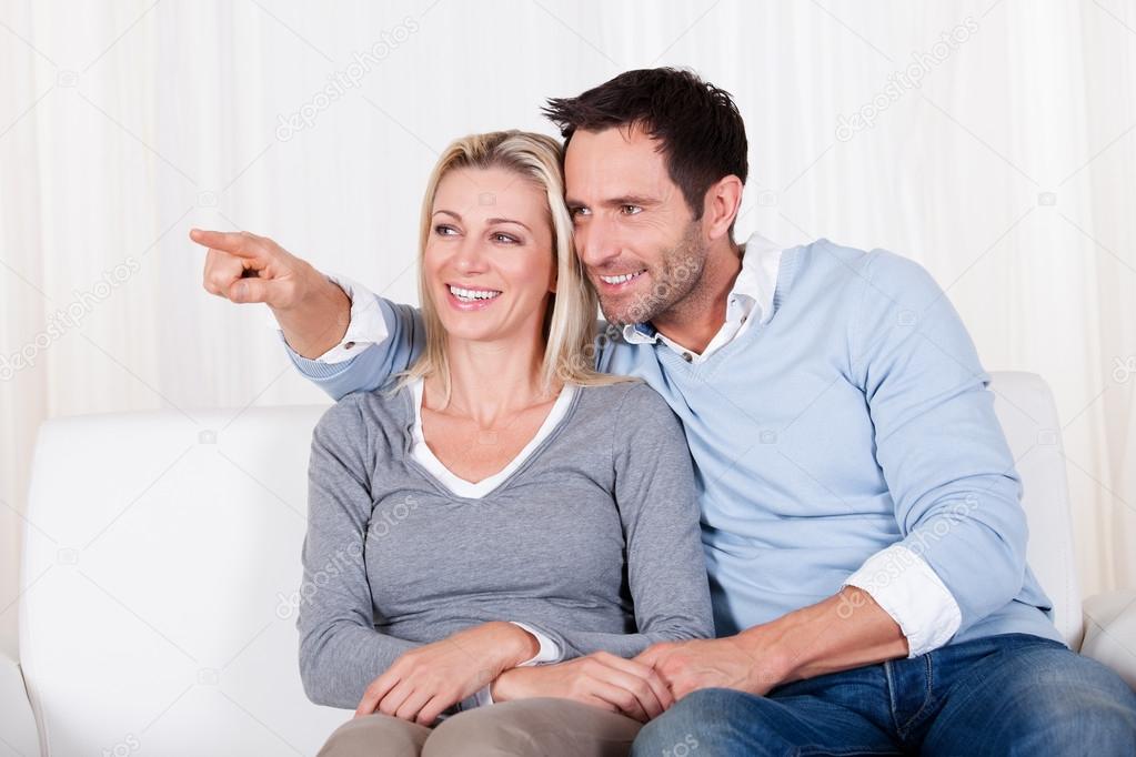 Laughing couple pointing off screen