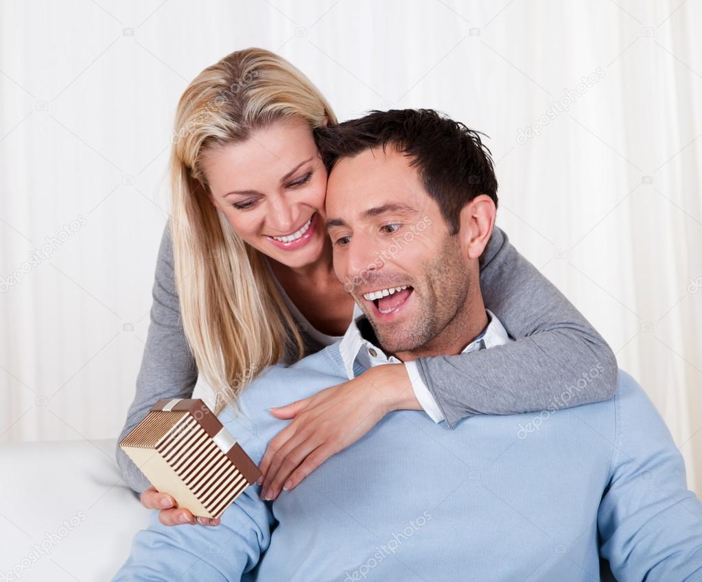 Woman giving her husband a surprise gift