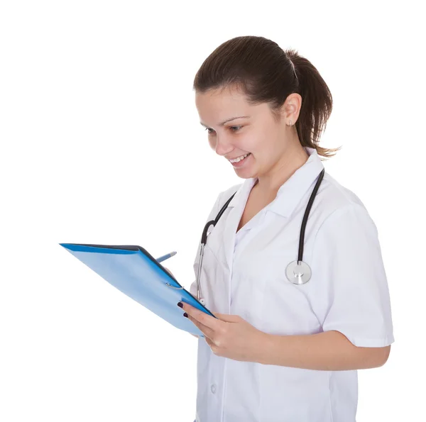 Cheerful young nurse writing a report — Stock Photo, Image