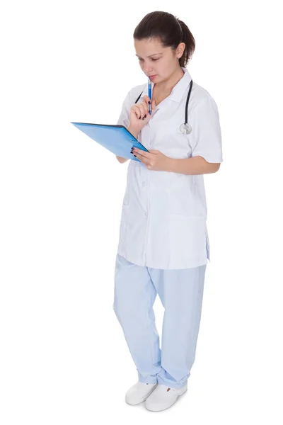 Cheerful young nurse writing a report — Stock Photo, Image