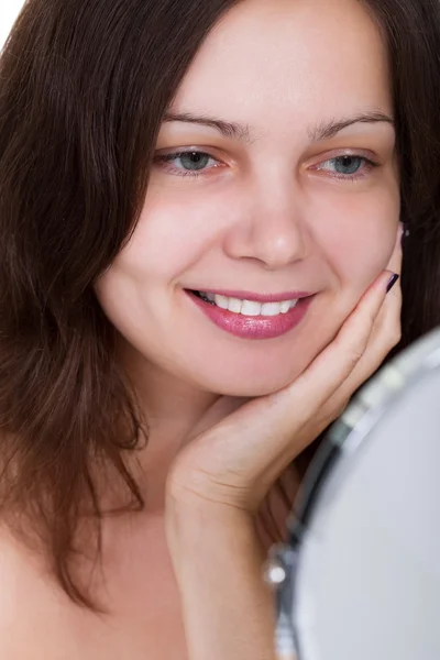 Mulher sorrindo para si mesma no espelho — Fotografia de Stock