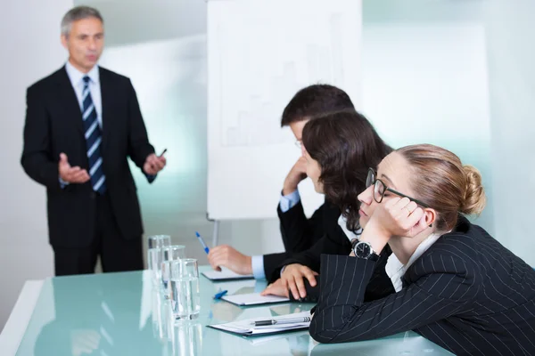 Gelangweilte Geschäftsfrau schläft in einem Meeting — Stockfoto