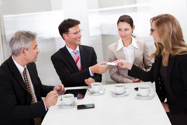 Geschäftsleute tauschen bei Kaffee Karten aus — Stockfoto