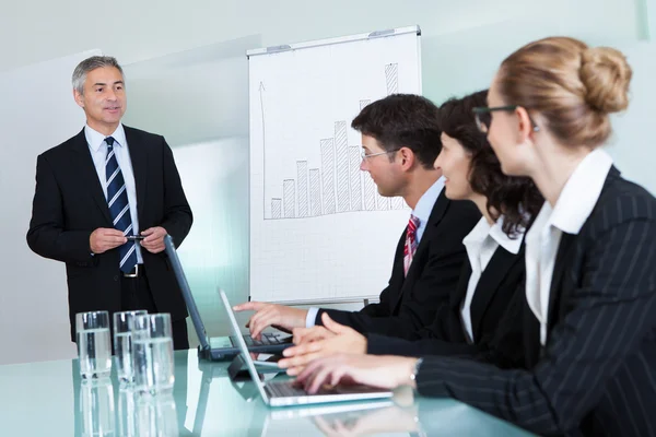 Businesspeople working on laptops and tablets Stock Picture