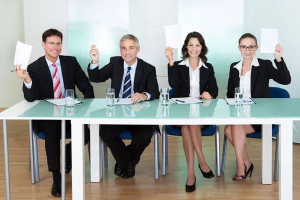 Group of judges holding up blank cards — Stock Photo, Image