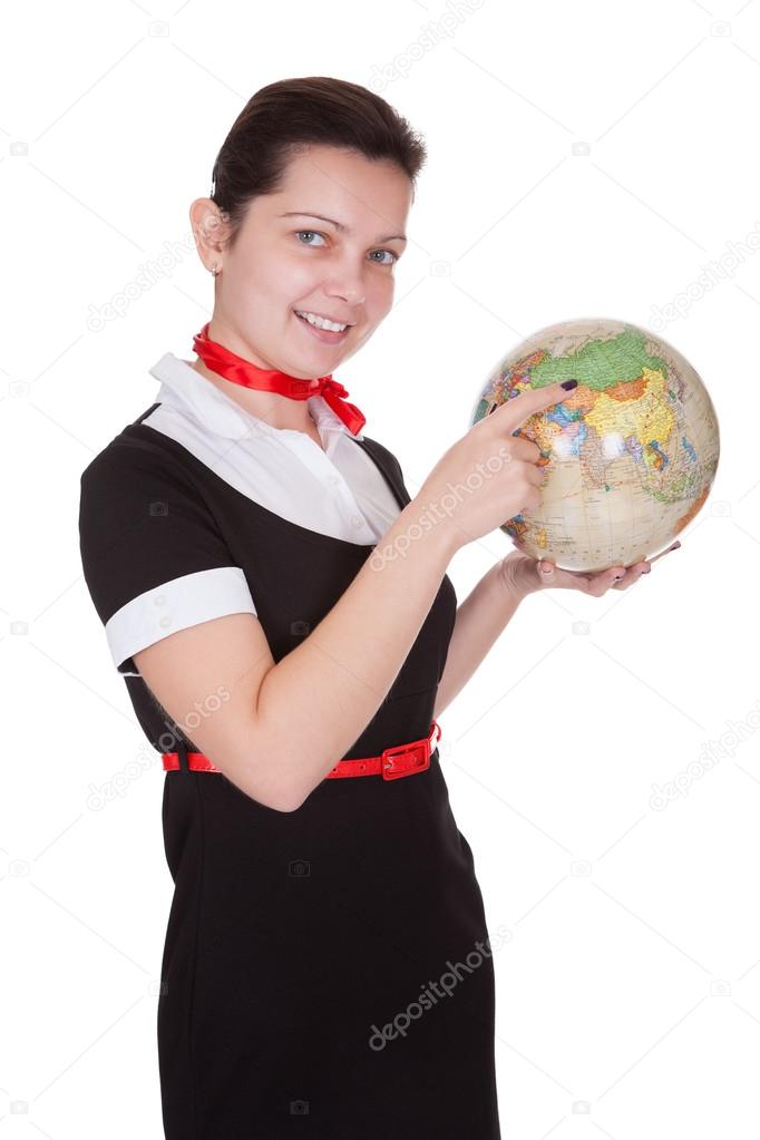 Pretty flight attendant holding a globe