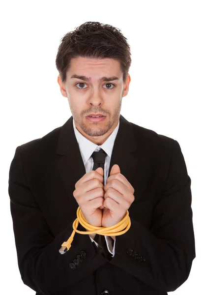 Empresário com as mãos amarradas em cabo de rede — Fotografia de Stock