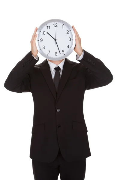 Businessman holding clock over the face — Stock Photo, Image